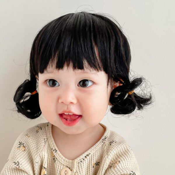 Perruque à franges et ondulations brunes pour petite fille. Enfant qui sourit avec de grands yeux.