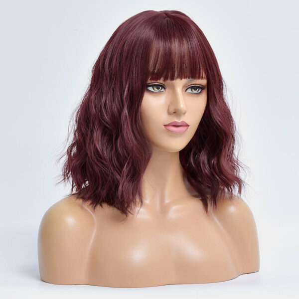 Buste de mannequin avec une perruque rouge bordeaux ondulées avec une frange