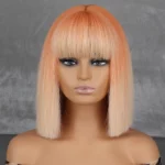 Mannequin de tête sur fond gris avec perruque orange carré mi-longue aux cheveux lisses