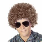 Perruque courte aux cheveux bouclés pour homme style disco sur homme aux lunettes de soleil aviateur.
