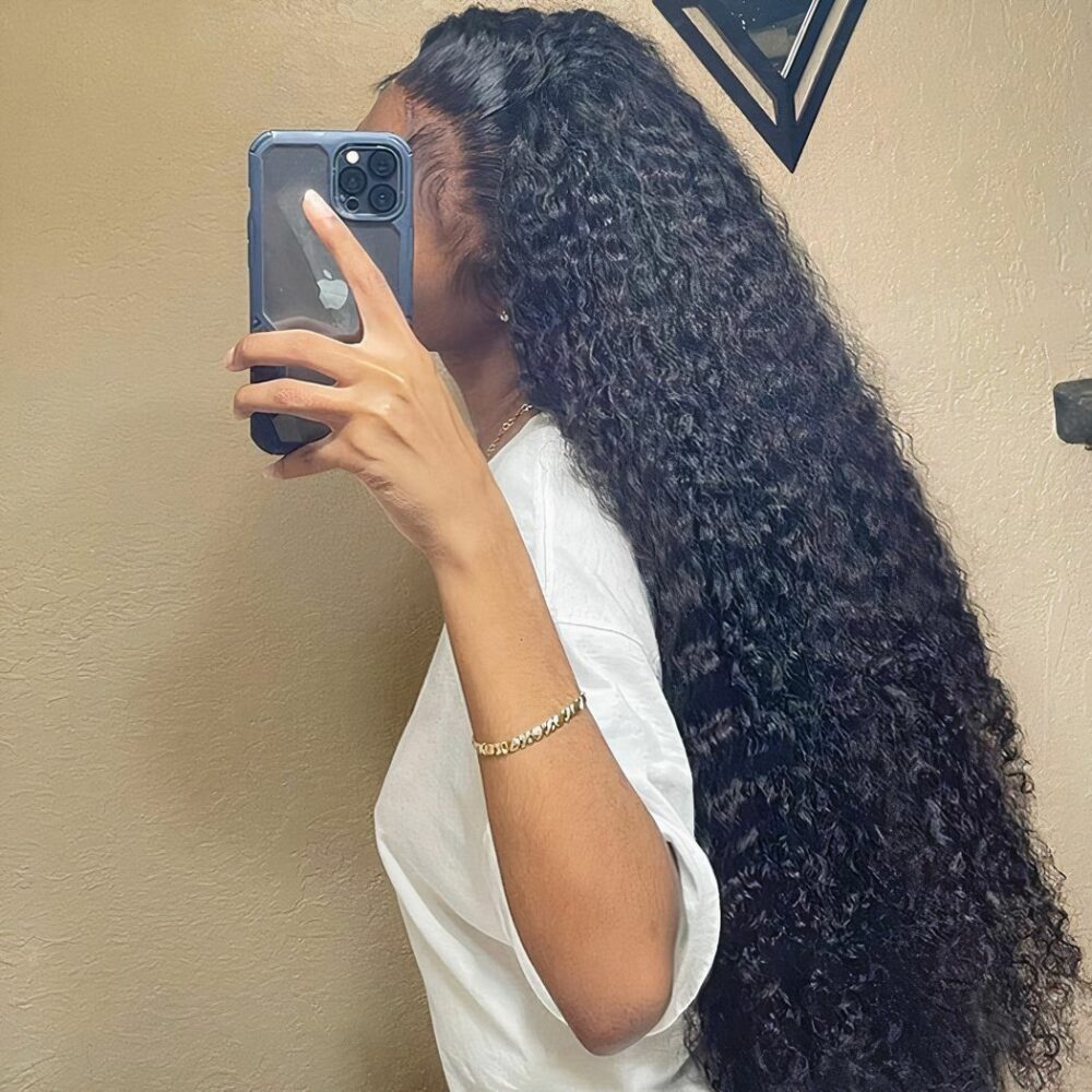 Femme avec un perruque brune bouclée avecu n t-shurt blanc qui se prend en photo avec son telephone dans un miroir avec un fond jaune